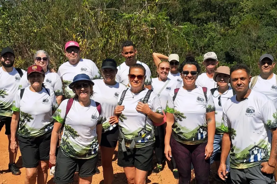 Grupo de caminhantes com a camisa do projeto, no alto da trilha